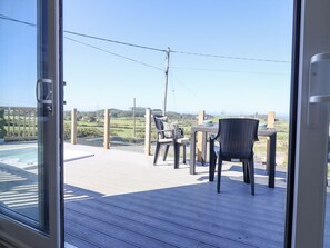 A deck with outdoor seating and a view of the landscape. - Posh Pod (Cemaes Bay)