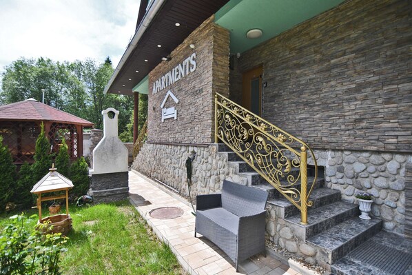A building with a stone facade, a sign reading 'APARTMENTS,' and a staircase with ornate golden railings. -     Modern Apartment in High Tatras, Near Štrbské Pleso, AC, WiFi (Tatranská Strba)