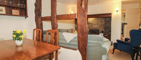 Une pièce comprenant une table à manger en bois, des chaises, un canapé et un fauteuil bleu.