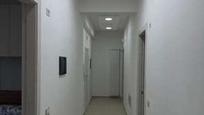 A narrow hallway with white walls, a carpeted floor, and recessed ceiling lights. - B&B le Pontine (Gaeta)
