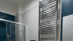 A modern bathroom with a glass shower enclosure, a toilet, a bidet, and a sink with a wooden vanity. - B&B le Pontine (Gaeta)