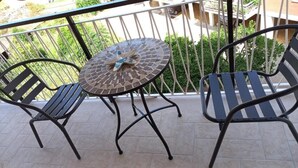 A balcony with a round table and two chairs, a tiled floor, and a metal railing. - B&B le Pontine (Gaeta)