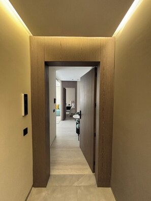 Ein Flur mit Holztürrahmen, Lichtschalter und einer Nummer auf der Wand.