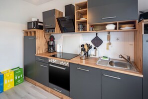 A modern kitchen with a built-in oven, microwave, and a sink.