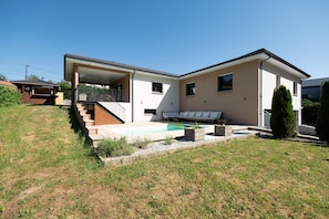 A modern two-story house with a covered patio, a swimming pool, and a small garden area. - Superb Peaceful House with Pool (Chantraine)