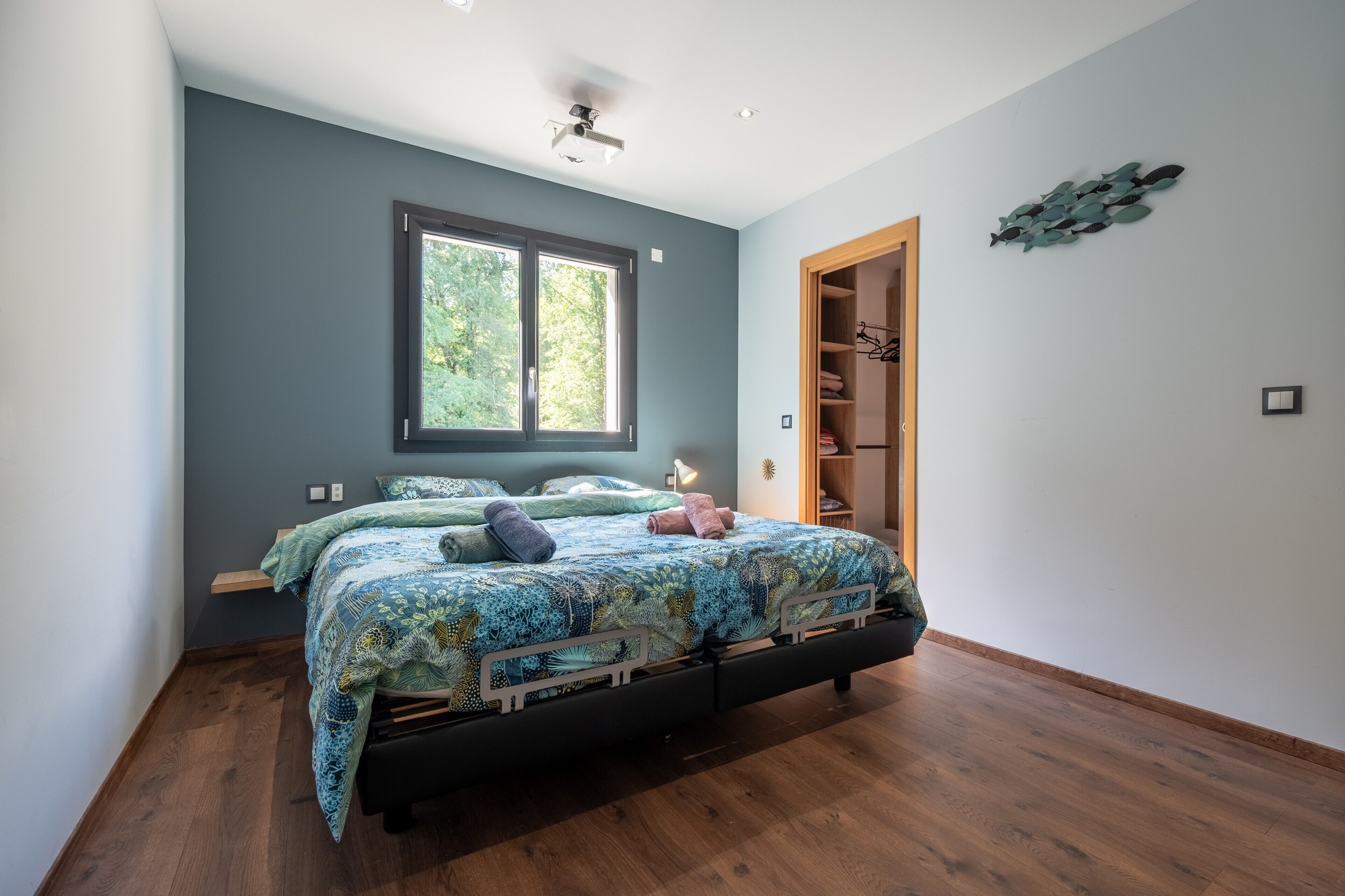 A bedroom with a bed, a window, a closet, and a ceiling fan.
