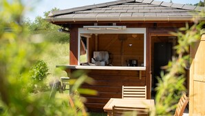 Una cabaña de madera con balcón, una mesa y una silla.
