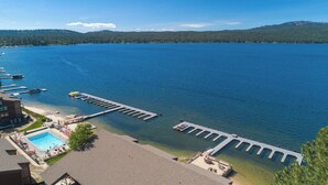 Una propiedad frente al agua con piscina, muelle y vistas despejadas del lago y el bosque circundante.