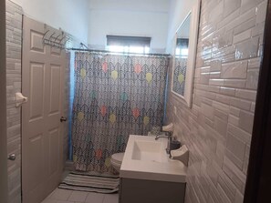 A bathroom with a shower curtain, a sink, and a mirror. - Two,2bedrooms apartment in amazing Argyle wth AC and comfort (Argyle)