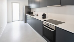 Eine moderne Küche mit Geschirrspüler, Kochfeld und Mikrowelle.