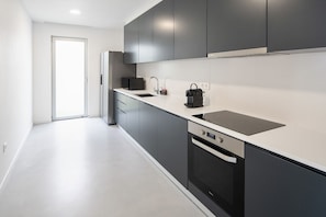 Eine moderne Küche mit Geschirrspüler, Kochfeld und Mikrowelle.