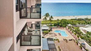 Ett hotell med pool, utomhusservering och utsikt över stranden.