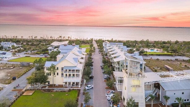 A coastal residential area with a row of houses, a central walkway, and a view of the ocean.
