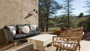 An outdoor seating area with a sofa, a coffee table, and wicker chairs. - Peaceful Pool and Tub Bliss with Majestic Thunder Mountain Views (Sedona)