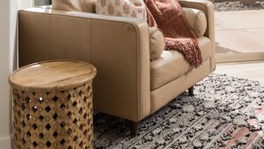 A modern living room with a large window, a sofa, a lamp, and a patterned rug. - Peaceful Pool and Tub Bliss with Majestic Thunder Mountain Views (Sedona)