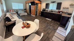 Ein zeitgemäßer Wohnraum mit Essbereich, Küche und Schlafzimmer.