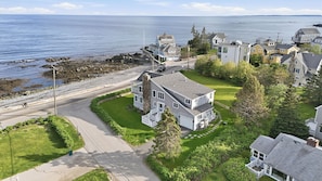 A coastal residential area with houses, a road, and a rocky shoreline. - Sun-Drenched Coastal Escape on Kennebunk Beach (Kennebunk)