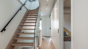 A modern staircase with glass railings, wooden steps, and a white interior. - Downtown Toronto row house. Close to Ossington, Trinity Bellwood & BMO field. (Toronto)