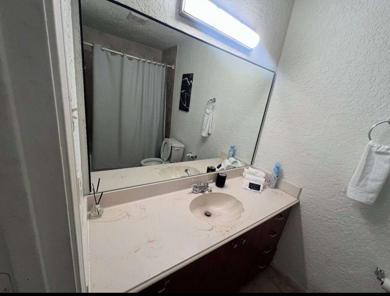 Un baño con lavabo, espejo y barra para toallas.