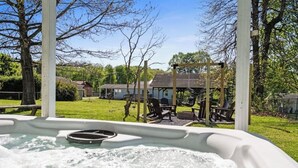 A hot tub with a view of a grassy area, a gazebo, and a house in the background. - Sleeps 16 • Hot Tub • Egg Chairs • Pool Table • 4 bedroom • Near New River Gorge (Oak Hill)