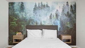 A bedroom with a large bed, two nightstands, and a forest-themed wallpaper. - Sleeps 16 • Hot Tub • Egg Chairs • Pool Table • 4 bedroom • Near New River Gorge (Oak Hill)
