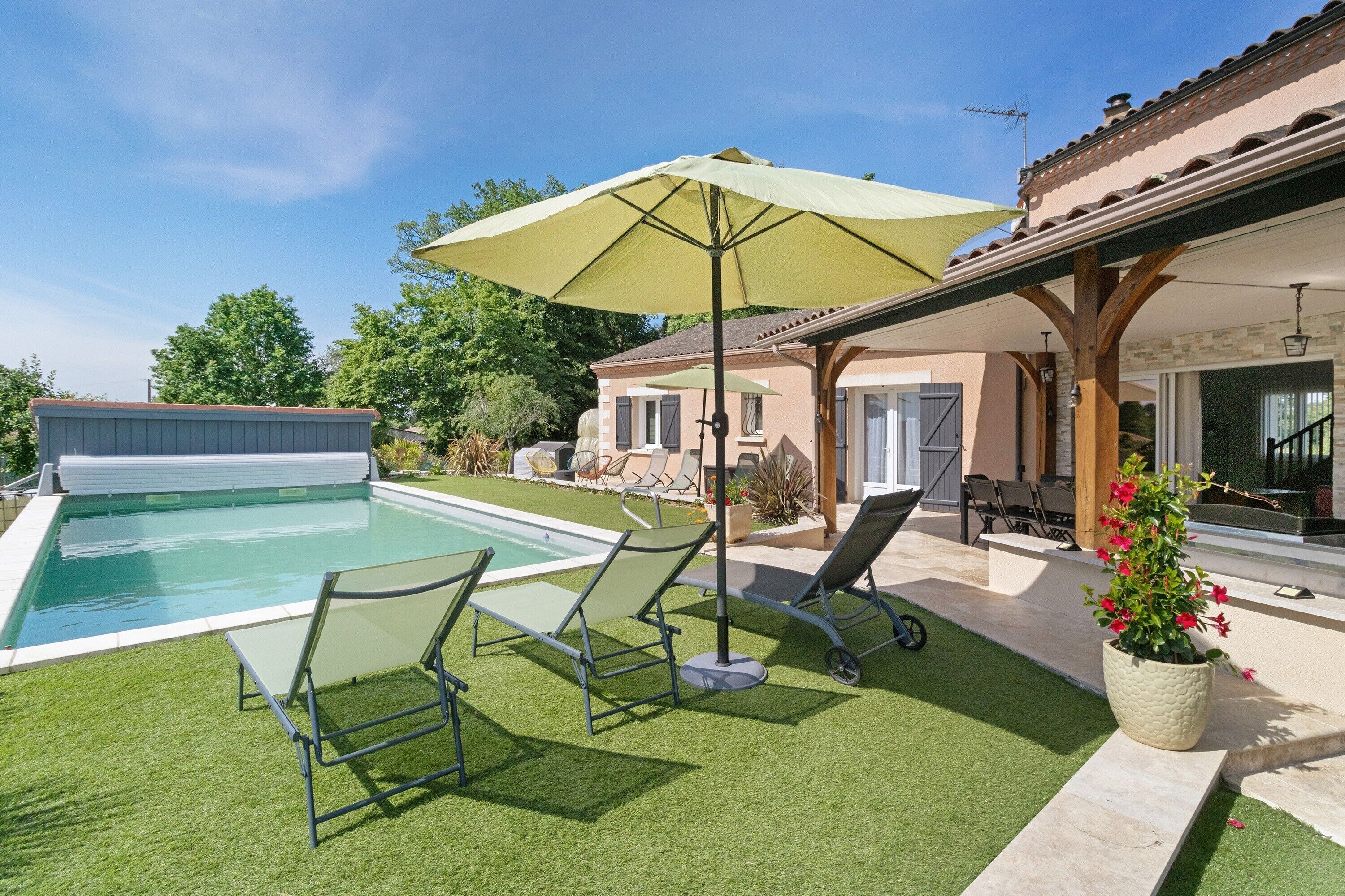 Une piscine avec des chaises longues, un patio couvert et une maison avec un toit en tuiles.