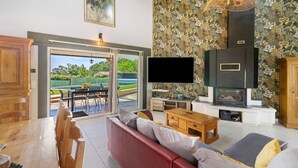 A living room with a sofa, TV, wooden table, and a fireplace.