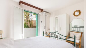 A bedroom with a bed, a wardrobe, a chair, and a mirror. - Villetta Sole e Sale - Trilo by BarbarHouse (Campomarino)