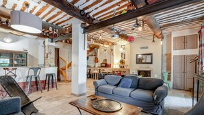 Una zona d'estar acollidora amb un sofà, una taula de cafè i una barra de fons.