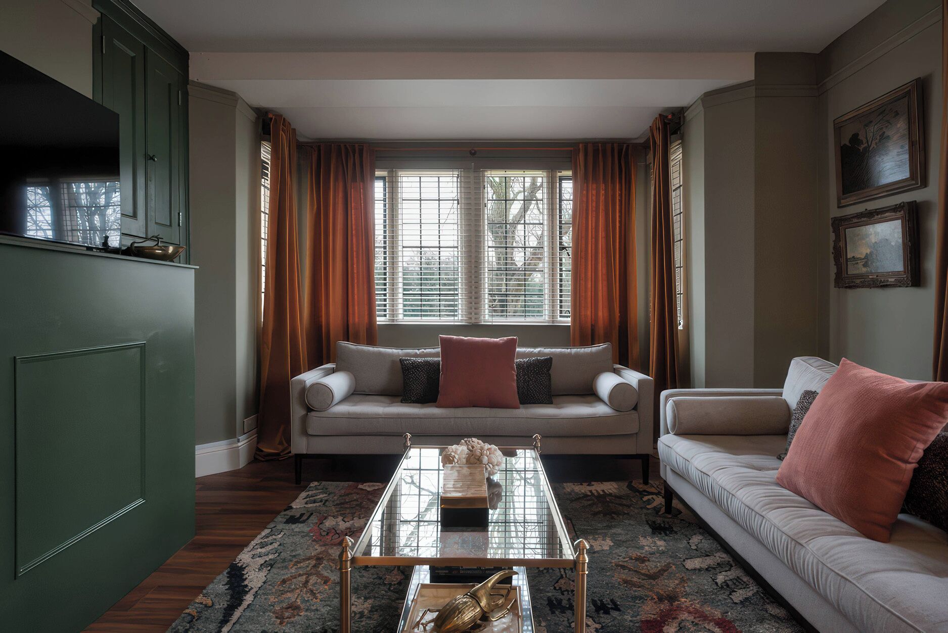 A living room with a sofa, a glass coffee table, and a view through a window with curtains.