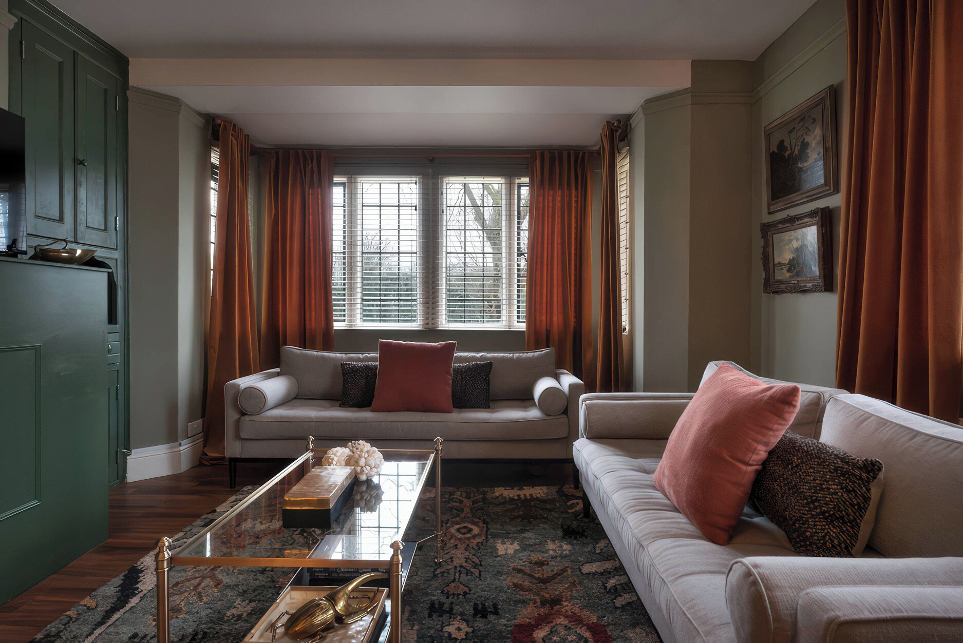 A living room with a sofa, a coffee table, and a window with curtains.