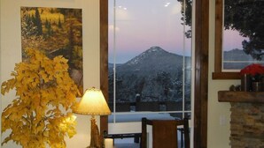 A room with a view of a snowy mountain, a lamp, a chair, and a fireplace. - Hot tub, mtn views, massage chair, & steam shower! (Divide)