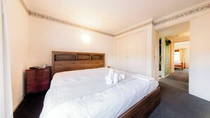 A hotel room with a large bed, a wooden headboard, a nightstand, and a wardrobe. - Peace and Love 2 BDR Townhouse West Melbourne (West Melbourne)
