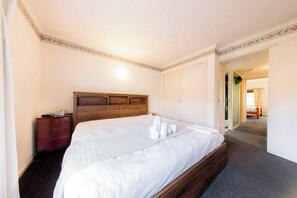 A hotel room with a large bed, a wooden headboard, a nightstand, and a wardrobe. - Peace and Love 2 BDR Townhouse West Melbourne (West Melbourne)