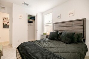 A bedroom with a bed, a nightstand, a window with blinds, and a closet with hanging clothes. - 4bd/2.5bth, 8 guests, Pet friendly (Dallas)