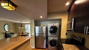 A modern kitchen with stainless steel appliances, a granite countertop, and a dining area with a wooden table and chairs. - Beautiful 2-bedroom, 2 bathroom villa in South Forest Beach. Hilton Head Island (Hilton Head Island)