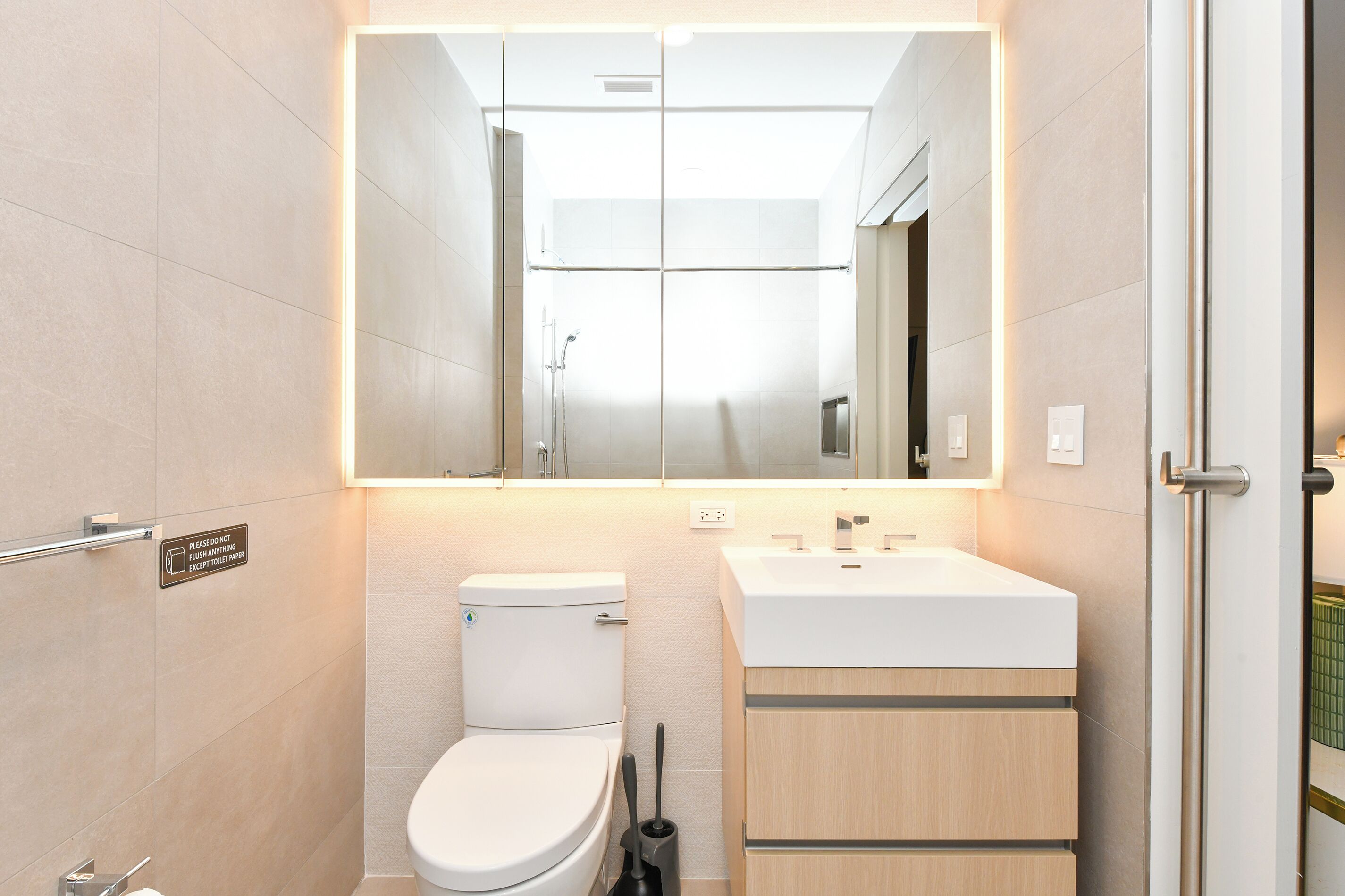 Une salle de bain moderne avec des toilettes, un lavabo et un miroir.