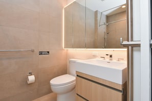 Een moderne badkamer met toilet, wastafel en spiegel.