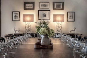 A conference room with a long table set for a meeting, surrounded by framed architectural drawings on the walls. - The Lady Rothschild Stables (Peterborough)