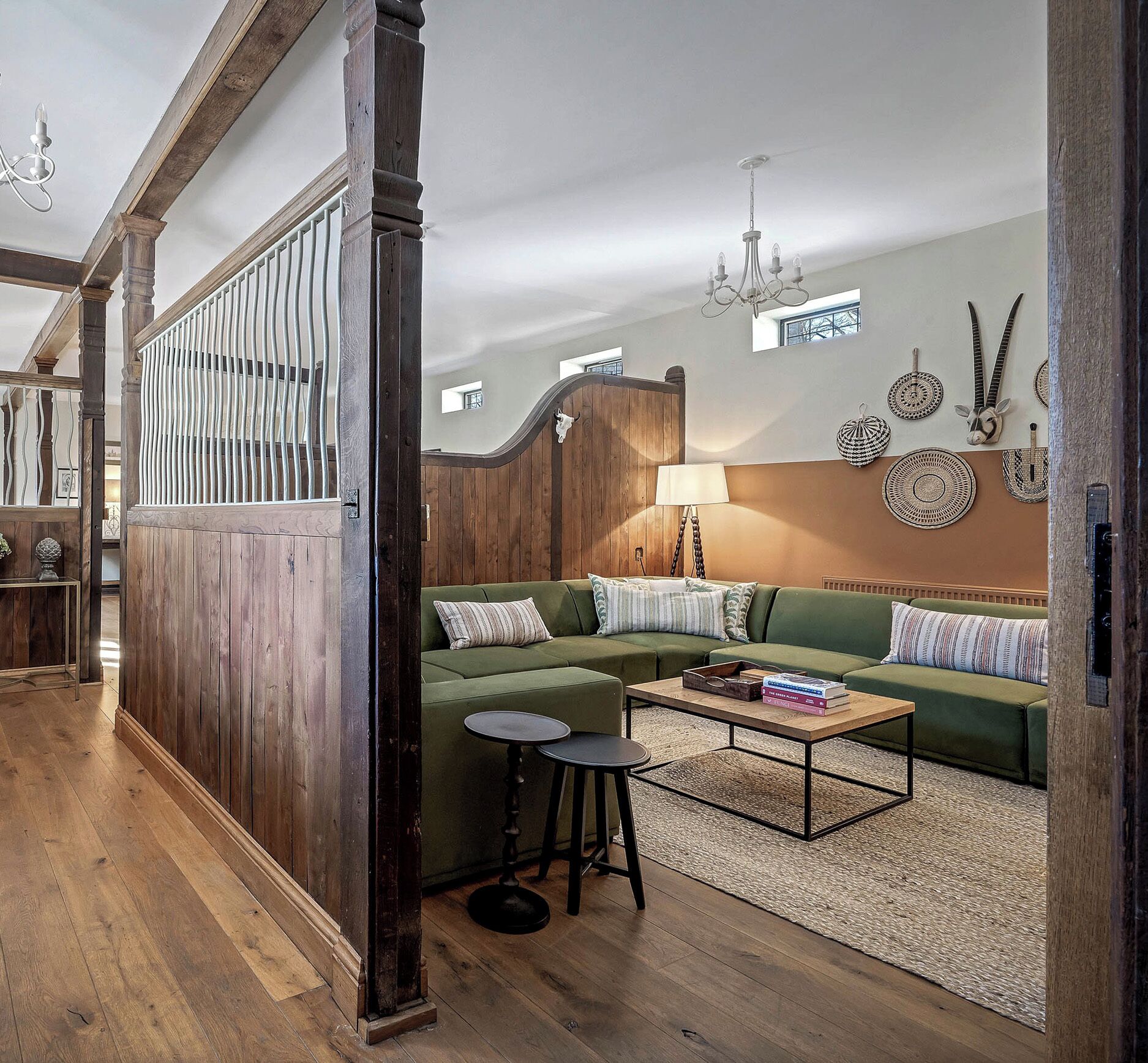 Un salon chaleureux avec un canapé vert, une table basse en bois et une lampe.