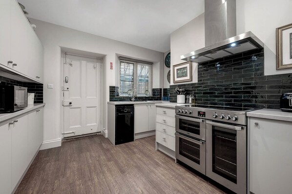A compact kitchen with a dishwasher, oven, and microwave. - Greenwood Manor (Peterborough)