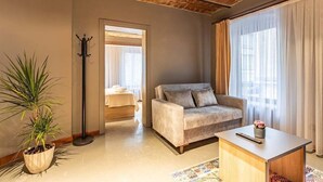 A modern living room with a sofa, a coffee table, a potted plant, and a floor lamp. - Bdıno boutıque hotel (Istanbul)