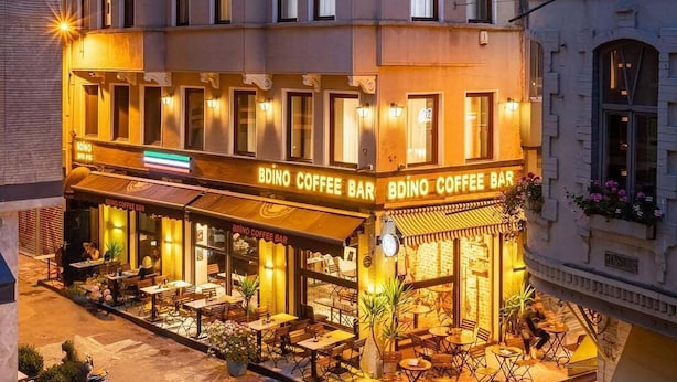 A multi-story building with a ground-level coffee bar named 'BDINO COFFEE BAR' featuring outdoor seating and a balcony. - Bdıno boutıque hotel (Istanbul)
