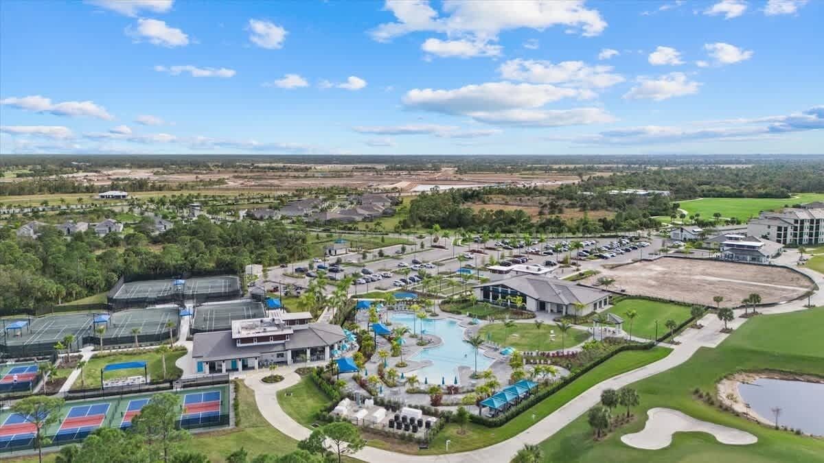 A golf course with a swimming pool, tennis courts, and a large building complex.