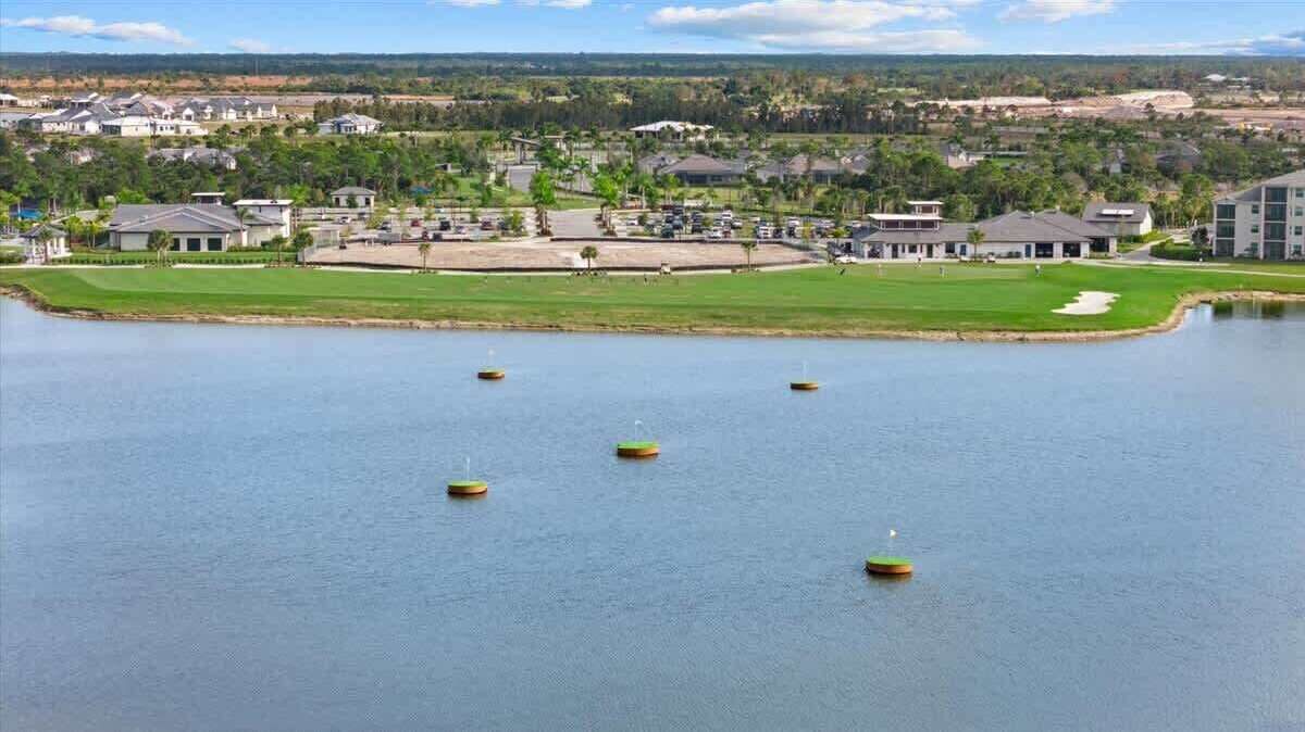 Uitzicht op een meer met een golfbaan, gebouwen en een heldere lucht.