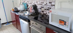 Una cocina equipada con lavavajillas, cafetera y microondas.