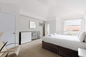A bedroom with a bed, a desk, a chair, a dresser, and a window. - Brilliantly Located 1BD Flat by Piccadilly Circus (Greater London)