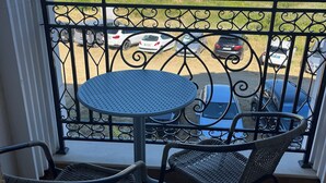 A balcony with a table and two chairs, overlooking a parking area and buildings. - Two-room apartment 350 m from the beach, good infrastructure, quiet location (Sweti Wlas)
