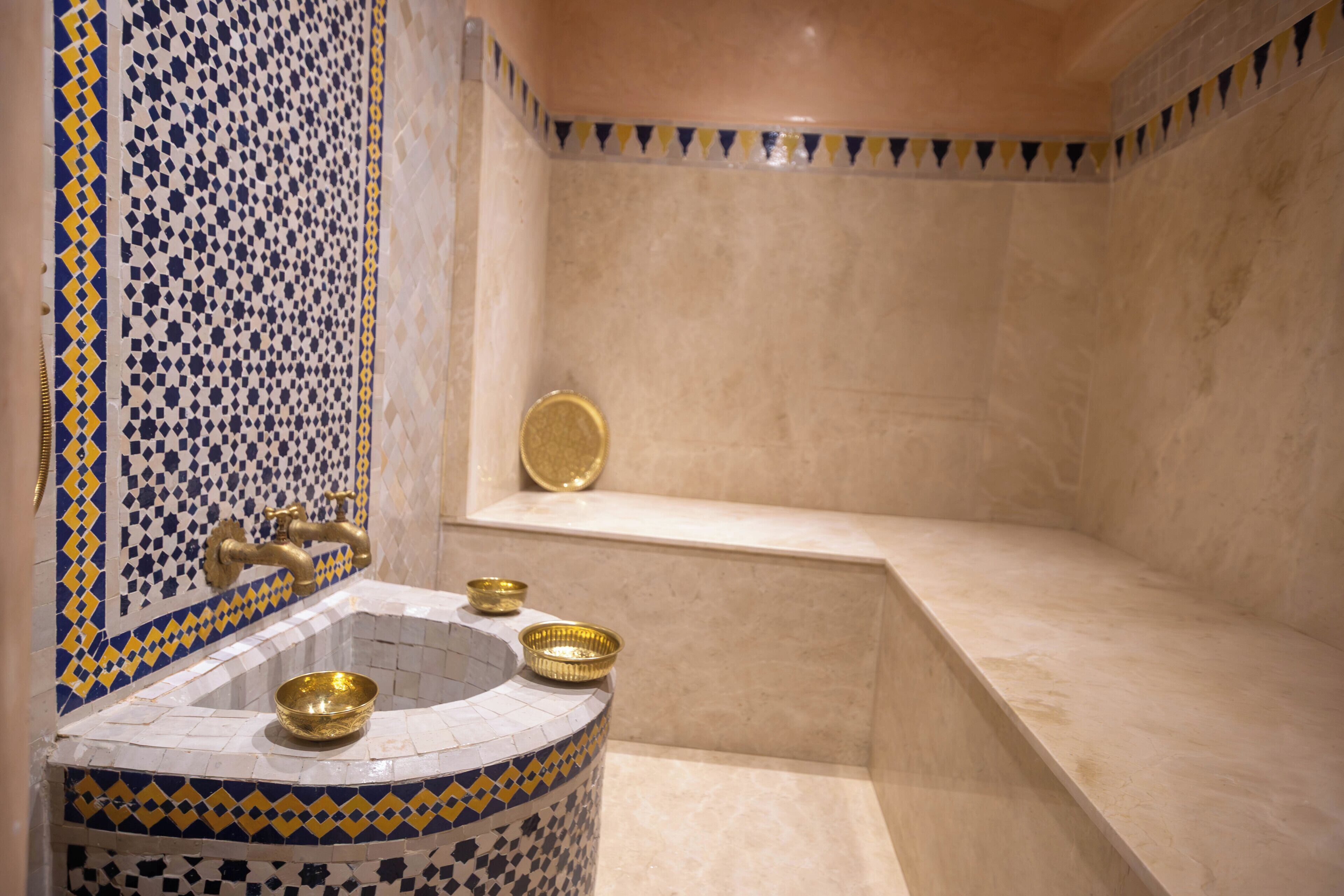 A bathroom with a tiled sink, a bathtub, and a shower area.