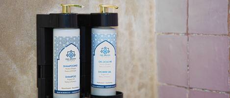 Two bottles of Dar Amanit hair products mounted on a wall.